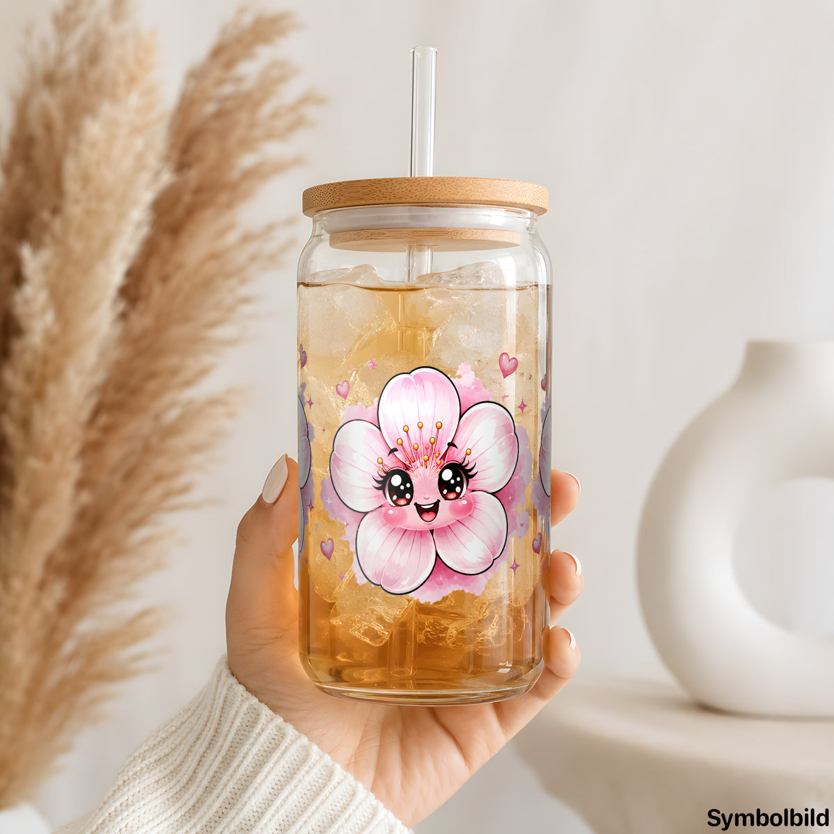 Zarte Blüten mit Gesicht als UV-DTF Sticker auf einem 16oz Glasbecher